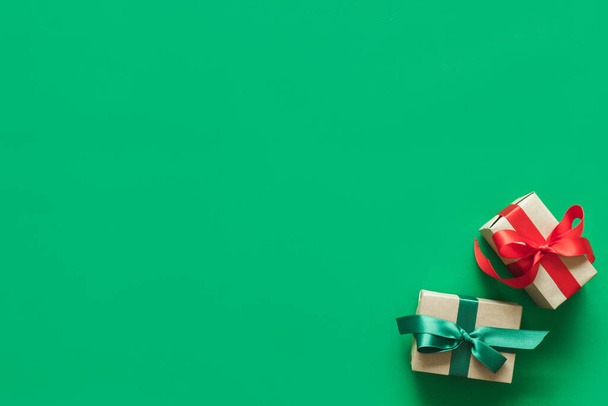 Різдвяний фон з подарунком на зеленому фоні з копіювальним простором. плоский вид зверху
 - Фото, зображення