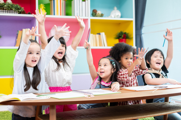 Групповое разнообразие детей, учащихся в школе, поднимая руки и наслаждаться в классе, концепции детского образования - Фото, изображение