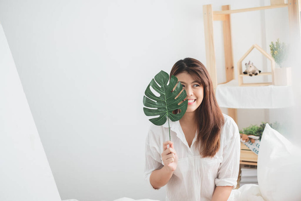 Portrait beau style de vie de femme asiatique avec feuille verte dans la chambre à coucher - Photo, image