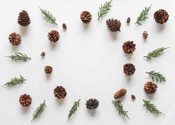 Christmas background, frame with fir branches tree pinecone over white background. flatlay copy space - Фото, изображение