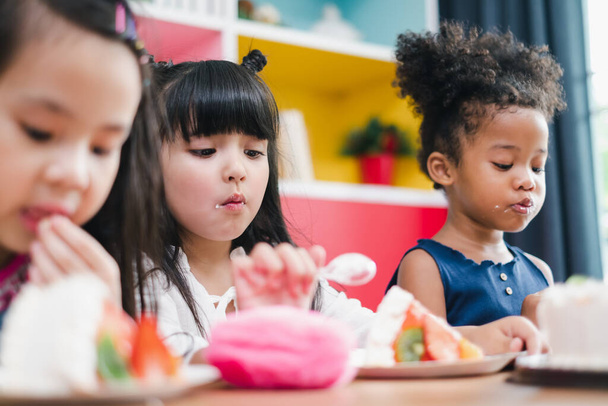 Diversidad niña niños comiendo pastel dulce - Foto, imagen