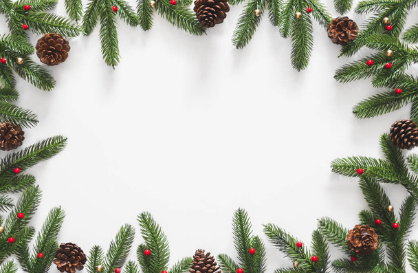 Christmas background, frame with fir branches tree pinecone over white background. flatlay copy space - Photo, Image