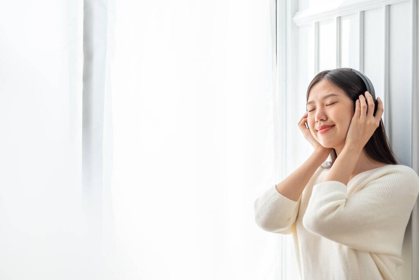Nuori kaunis aasialainen nainen kuunnella laulun musiikkia kotona, onnellinen elämäntapa käsite - Valokuva, kuva
