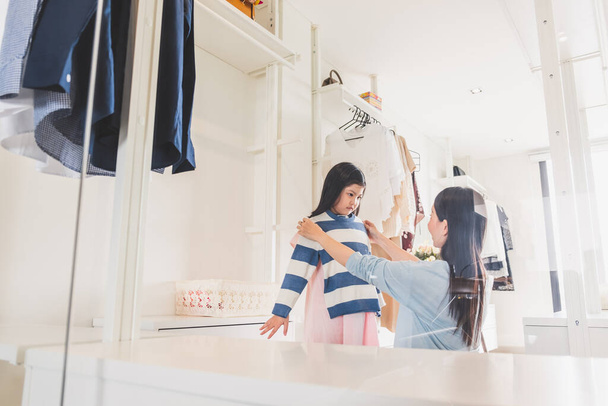 Madre asiática vestirse / elegir ropa a su hija niña de armario en el dormitorio, concepto de estilo de vida familiar asiática - Foto, Imagen