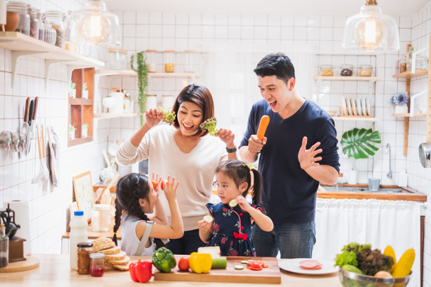 Ασιατική οικογένεια απολαμβάνουν το παιχνίδι και το μαγείρεμα των τροφίμων στην κουζίνα στο σπίτι - Φωτογραφία, εικόνα