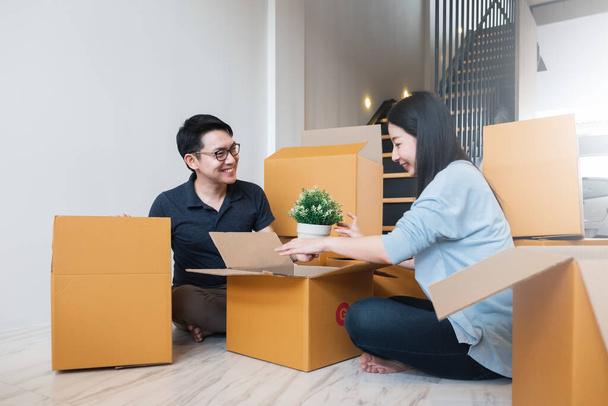 Familia asiática mudándose a nuevo hogar / apartamento con muchas cajas de embalaje - Foto, Imagen