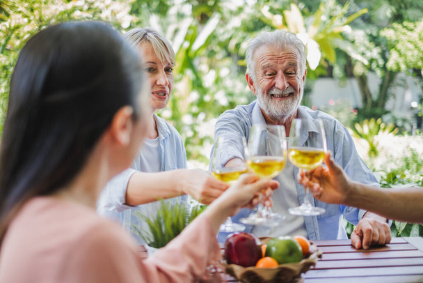 Grupo de personas mayores disfrutan de la fiesta en casa, beber vino blanco, cantar canciones para relajarse
 - Foto, imagen