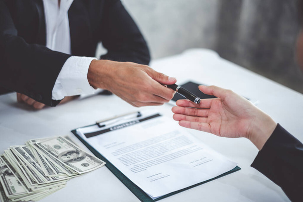 Uomo d'affari dando penna alla donna d'affari per la firma del contratto di prestito di denaro bancario - Foto, immagini