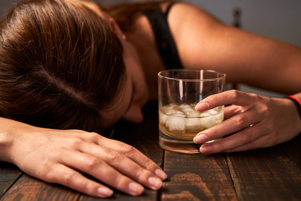Dronken vrouw met een glas alcohol. Begrip alcoholisme. - Foto, afbeelding