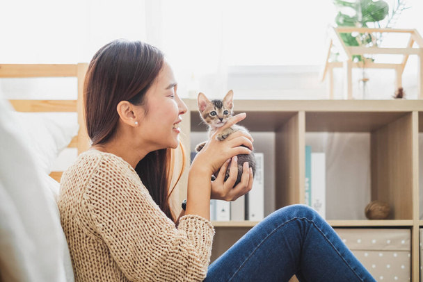 jong aziatische vrouw vasthouden en spelen met haar schattig katje met mooi moment huisdier en menselijk concept - Foto, afbeelding