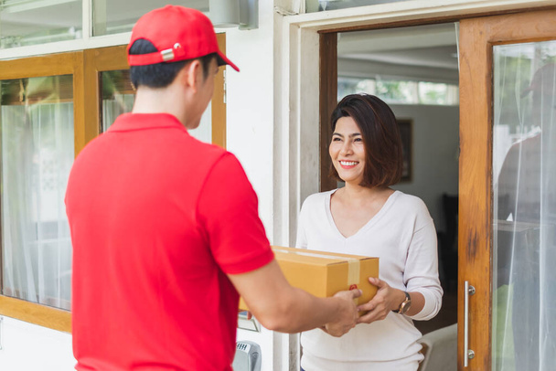 Asian delivery man deliver box parcel package to customer at home, shipping delivery concept - Photo, Image