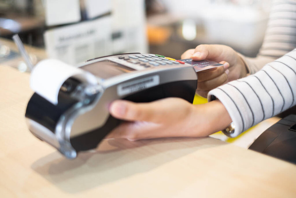 Klant gebruikt credit cart voor betaling aan eigenaar in cafe restaurant, cashless technologie en credit card betaling concept - Foto, afbeelding