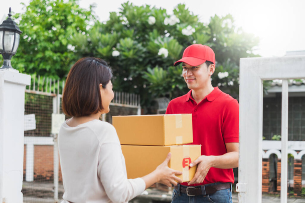 Uomo di consegna asiatico consegnare pacchetto pacco scatola al cliente a casa, concetto di consegna di spedizione - Foto, immagini