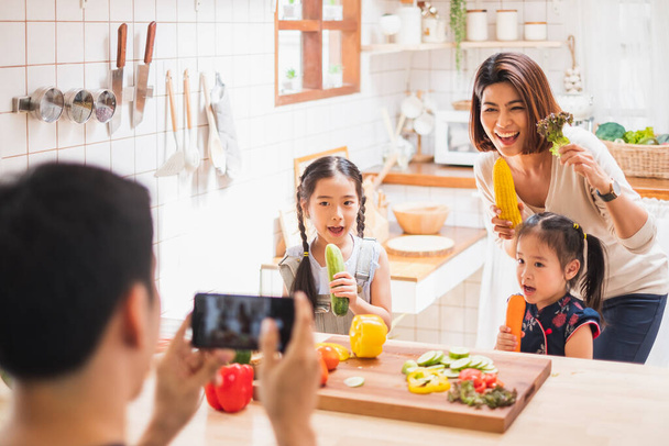Asiatische Familie genießt das Spielen und Kochen in der heimischen Küche - Foto, Bild