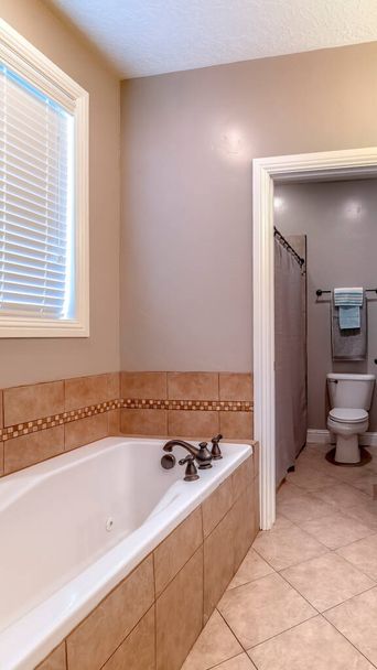 Vertikale Badezimmerausstattung mit Badewanne, Doppelwaschbecken, Schränken für Kosmetikspiegel und Fenster - Foto, Bild