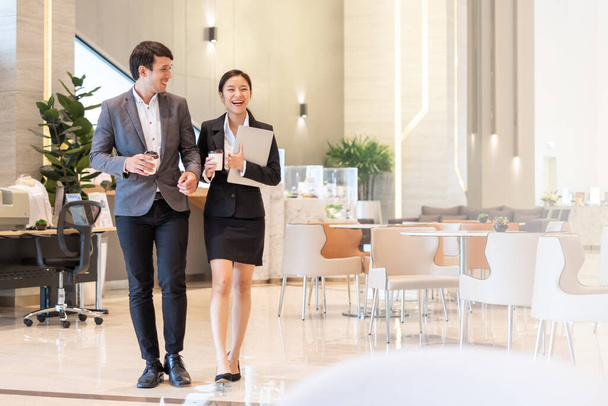 Gente de negocios asiáticos caminando y hablando con colegas en la oficina
 - Foto, Imagen