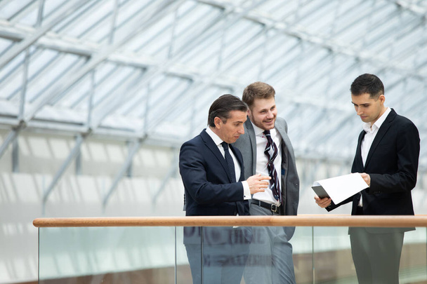 Business people having informal meeting in modern office discussing documents - Foto, afbeelding
