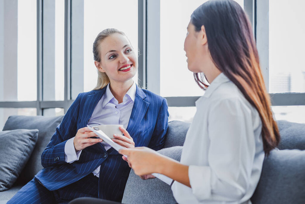 Two business woman making fits bump during talking and drinking coffee in office morning - Foto, Imagem