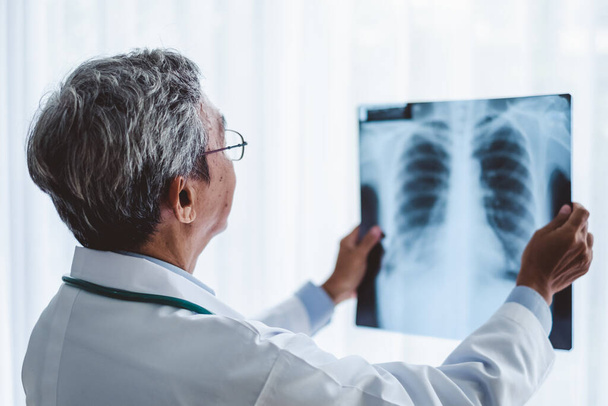 Aziatisch man arts diagnose patiënt x-ray radiografie film, aziatische medische concept - Foto, afbeelding