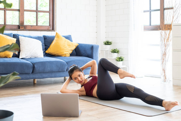 Joven Asiática saludable mujer entrenamiento en casa, ejercicio, ajuste, haciendo yoga, concepto de fitness en el hogar - Foto, Imagen