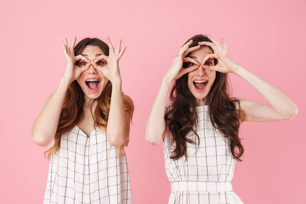 Image of cheerful nice women making fun and gesturing ok sign isolated over pink background - Φωτογραφία, εικόνα