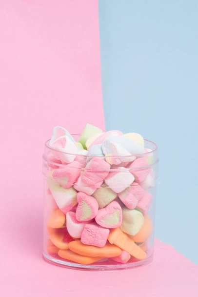 Δημιουργική διάταξη πολύχρωμων ζαχαρωτών και γλυκών σε παστέλ φόντο - Φωτογραφία, εικόνα