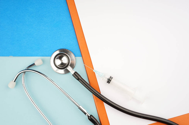 Medisch of gezondheidsconcept. Medische apparatuur zoals stethoscoop en spiraalvormige notitieblok op blauwe achtergrond. Vlakke lay-view. - Foto, afbeelding