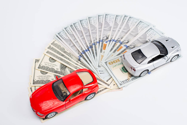 dollar banknotes with toy cars on white background - Photo, image