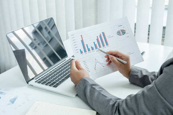 Bedrijfsvrouw berekenen financiële grafieken die resultaten tonen en analyseren financiële regelingen voor zakelijke investeringen. - Foto, afbeelding
