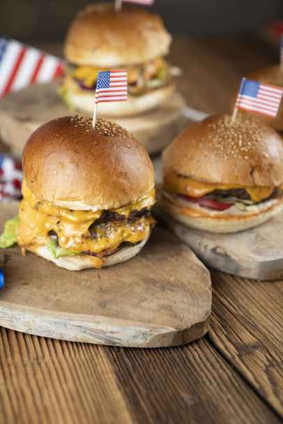 Fourth of July celebration. American flag and decorations. Burgers on rustic wooden table. - Fotó, kép