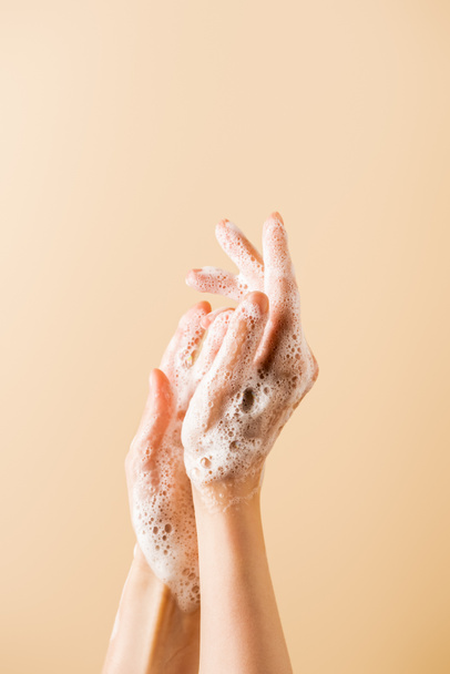 cropped view of female hands in soap foam isolated on beige - Zdjęcie, obraz