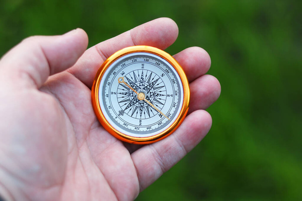 Starý klasický navigační kompas v ruce na přírodním pozadí - Fotografie, Obrázek