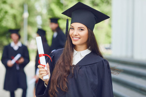 A young female graduate against the background of university graduates. - Foto, imagen