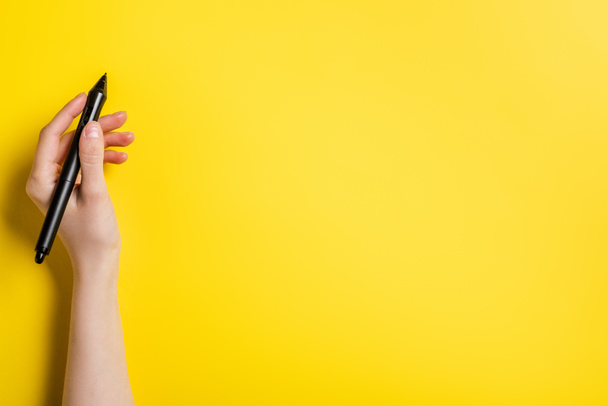 oříznutý pohled návrháře držícího černý stylus na žluté  - Fotografie, Obrázek