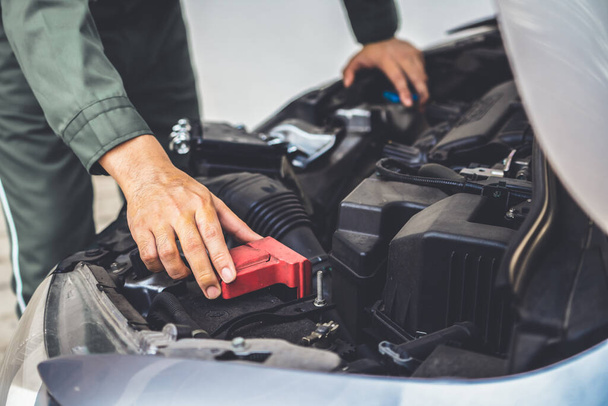 Professional mechanic hand providing car repair and maintenance service in auto garage. Car service business concept. - Foto, imagen