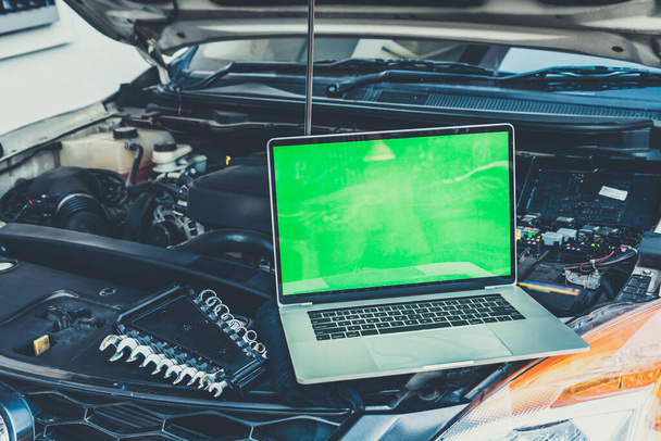 Laptop computer on car hood for engine diagnostic. Car garage repair service concept. - Foto, immagini