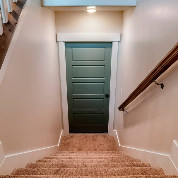 Quadratische U-förmige Treppe, die vom Erdgeschoss des Hauses zur Kellertür führt - Foto, Bild