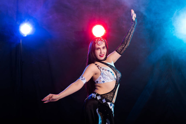 Girl dancing belly dance, fusion or tribal. A woman in a beautiful costume demonstrates charming and gentle movements in the dance. - Photo, Image