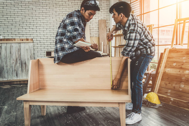 Carpenter working on wood craft at workshop to produce construction material or wooden furniture. The young Asian carpenter use professional tools for crafting. DIY maker and carpentry work concept. - Photo, Image