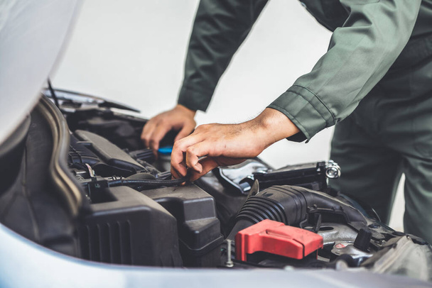 Professional mechanic hand providing car repair and maintenance service in auto garage. Car service business concept. - Foto, Imagem