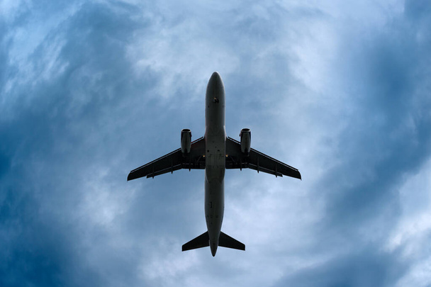 Avion dans une silhouette contre un ciel orageux dramatique - Photo, image