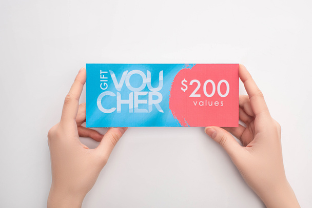 Top view of woman holding gift voucher with 200 values sign on white background - Foto, Imagen