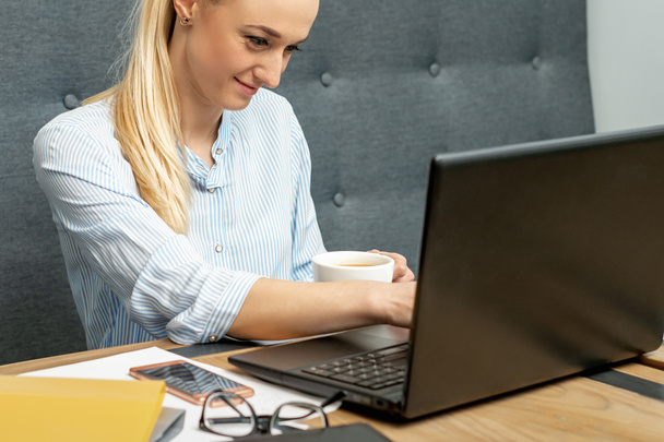 Jovem mulher está usando laptop durante a aprendizagem on-line em casa escritório
. - Foto, Imagem