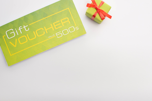Top view of gift voucher and present on white background with copy space  - Foto, immagini
