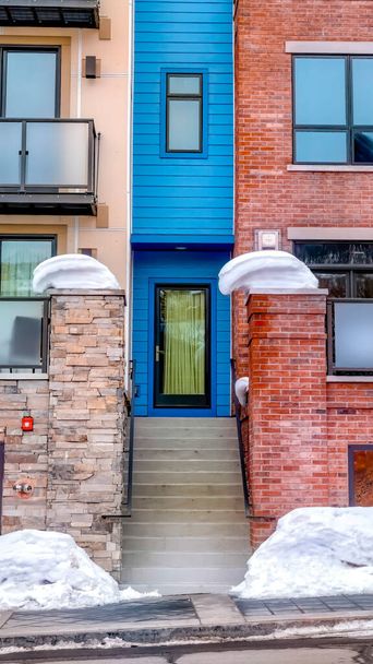 Verticaal gewas Woningbouw gevel met kleurrijke muur en balkons met glazen reling - Foto, afbeelding