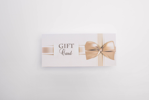 Top view of gift card with bow on white background - Foto, Imagem