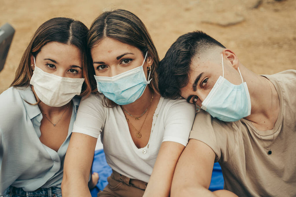 Friends in masks enjoying a summer day in a 2020 pandemic. - Фото, зображення