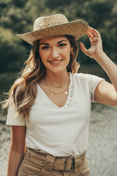 Giovane ragazza con cappello da cowboy su un lago in mezzo alla foresta in primavera
. - Foto, immagini