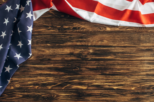 верхний вид американского флага со звездами и полосами на деревянной поверхности
  - Фото, изображение