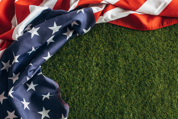 top view of american flag with stars and stripes on green grass outside, labor day concept  - Photo, Image